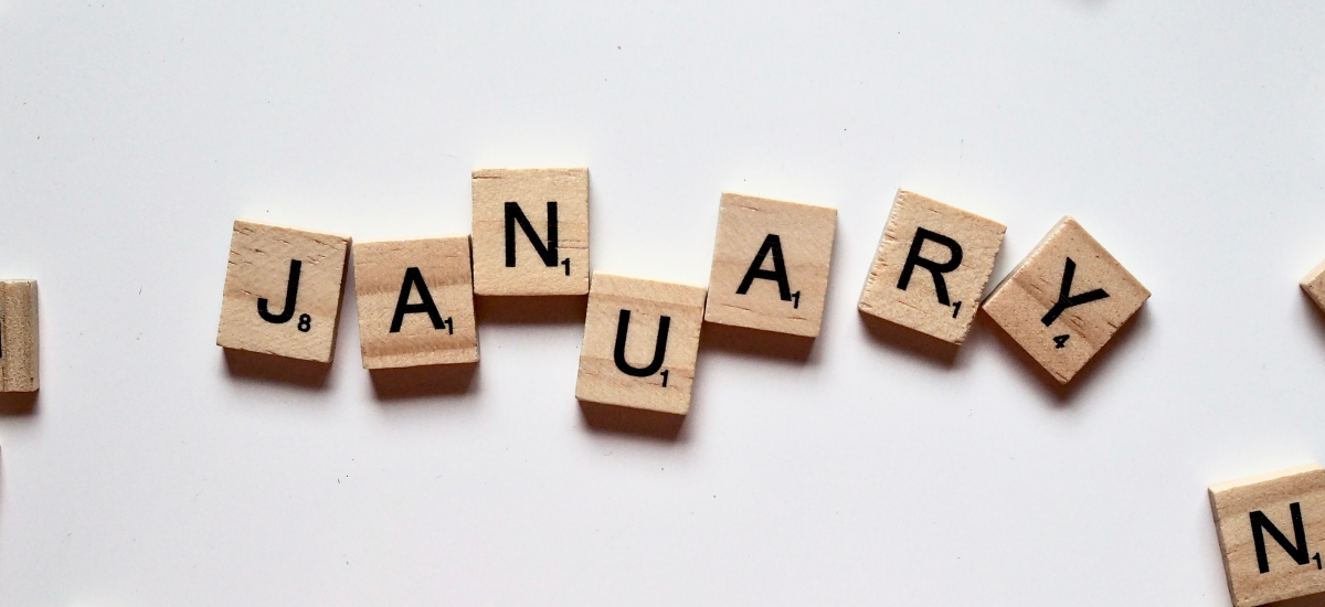 Scrabble-blokjes van hout, elk met een letter erop. De letters spellen samen het woord january
